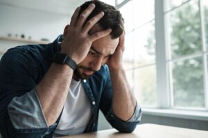man struggling with questions regarding agoraphobia vs social anxiety