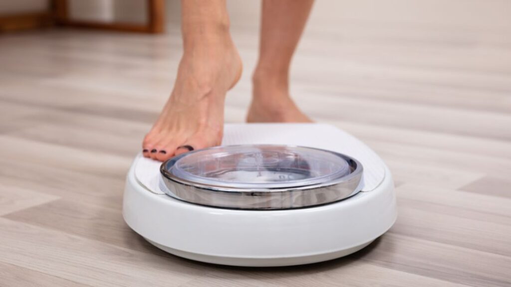 woman stepping on the scale wondering do anxi-anxiety medications cause weight gain?