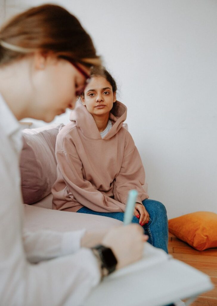 woman speaking with her therapist going over warning signs of schizophrenia