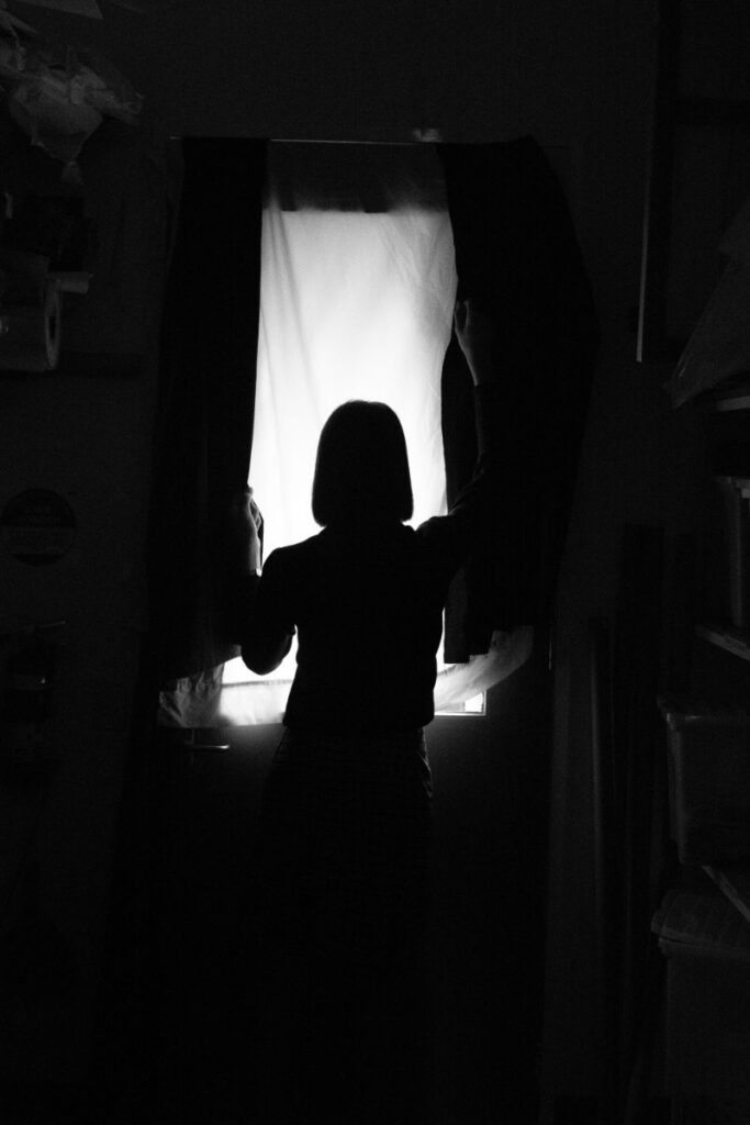 woman alone in a dark room struggles with depression