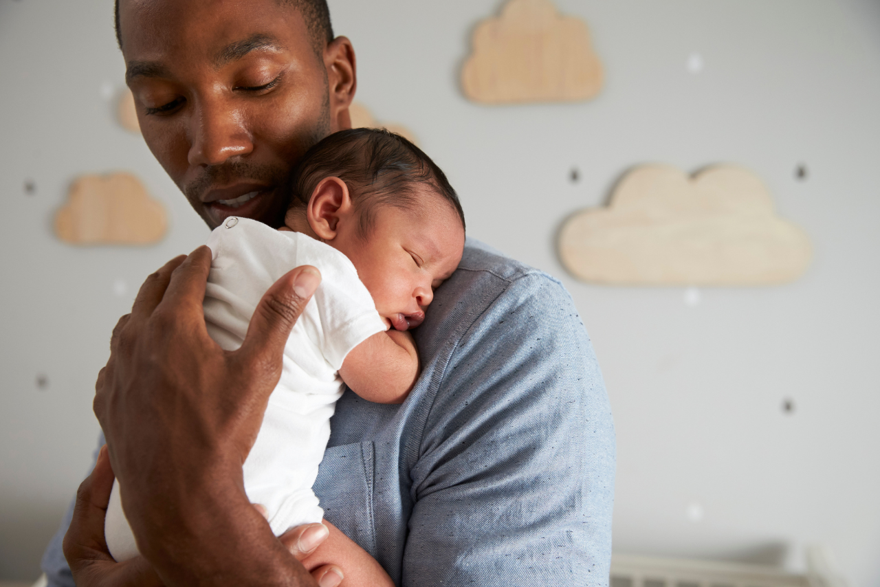 man holding his baby struggling with the question can men get postpartum depression?